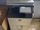 une imprimante posée sur un bureau près d'une fenêtre