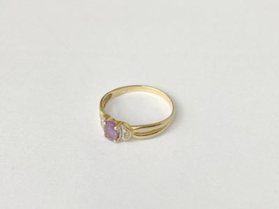 a close up of a gold ring with a pink stone on it