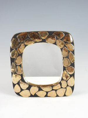 a close up of a square shaped mirror with rocks on it