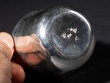 a hand holding a glass jar with a small star on it