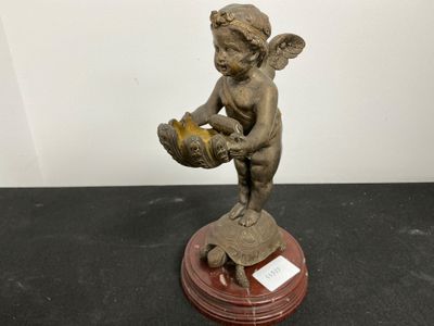 une petite statue représentant un petit garçon tenant un panier