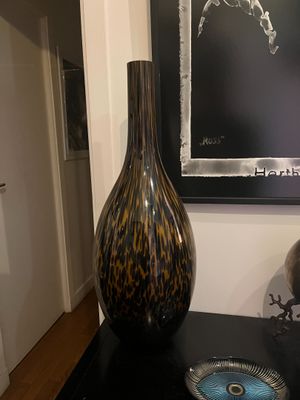 a black table with a vase on it next to a picture