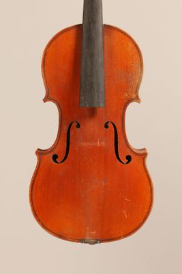 un vieux violon posé sur une surface blanche