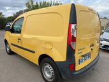 the back of a yellow van parked in a parking lot next to other cars