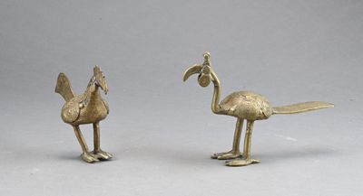 brass figurines of a bird and a flamingo on a gray background
