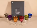 Quatre verres à vin sont alignés sur une table, avec une boîte en arrière-plan.