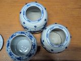 three blue and white vases sitting on a wooden table