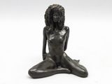 a statue of a woman sitting on the ground with her legs crossed