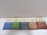 four books on a white table with a white wall in the background