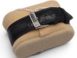 black leather watch case with a silver buckle on a white background