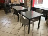 tables and chairs are lined up in a restaurant with a red door