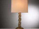une image représentant une lampe dorée surmontée d'un abat-jour blanc
