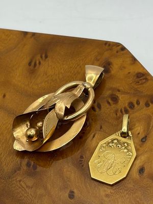 un objet plaqué or posé sur une table en bois, à côté d'une médaille d'or