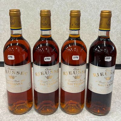 quatre bouteilles de vin sont alignées sur un comptoir