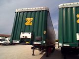 two trucks that are parked side by side in a parking lot