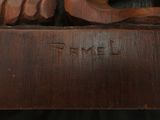 a wooden sculpture of a man holding a dog