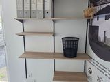 a picture of a room with shelves and a trash can in it