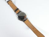 a watch that is sitting on a table next to a cell phone