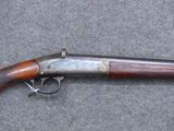 an old gun with a wooden handle on a gray surface