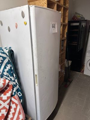 a white refrigerator in the corner of a room next to a washer and dryer