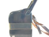 a black bag with a brown strap and a cell phone in it