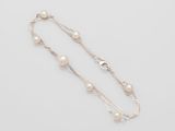 a close up of a necklace with pearls on a white background