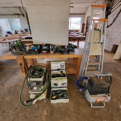 de nombreux outils posés sur un établi dans un bâtiment