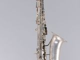 un gros plan d'un saxophone sur fond gris