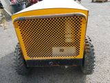 an image of a small yellow tractor parked in a parking lot