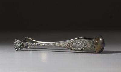 une cuillère en argent posée sur une table blanche, sur fond noir