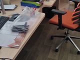 a desk with a computer and a chair in a room