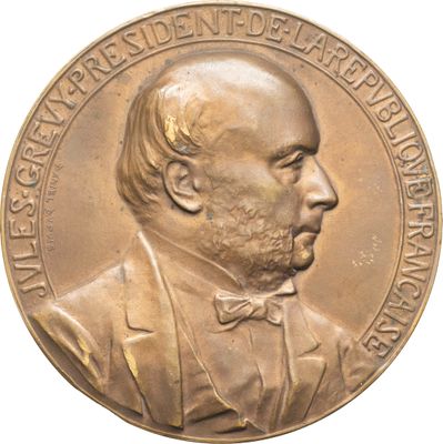 une image représentant une médaille de bronze sur laquelle figure un homme portant un nœud papillon