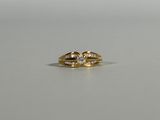 a close up of a gold ring with two diamonds on it
