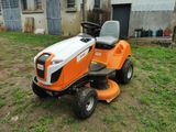 an orange and white riding lawn mower sitting on top of a grass covered field