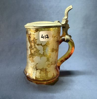 une coupe en or munie d'une anse sur fond gris