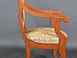 an antique wooden chair with upholstered seat and arm rest
