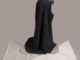 a black cloth on a table next to a piece of paper
