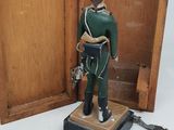 a toy soldier that is standing in front of a wooden box