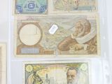 many different types of currency on display in a glass case