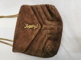 brown sued handbag with gold chain strap on white background