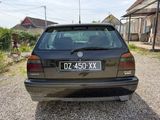 a black car that is parked in the gravel