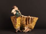 une figurine représentant une femme assise dans un panier