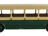 un petit bus en plastique posé sur une surface blanche