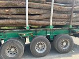 un camion avec un chargement de grumes à l'arrière