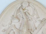a white relief of a woman holding a baby in her arms