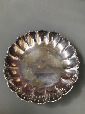 a close up of a silver plate sitting on top of a table