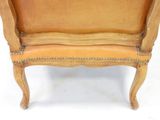 a wooden chair with a tan leather seat and back