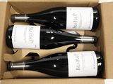 three bottles of wine are in a cardboard box on a table