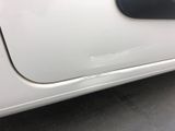 a white car with a black door handle and a sticker on it