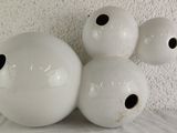 three white vases with holes in them on a table